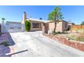 Exterior elevation of a single-story home with a concrete driveway and low-maintenance landscaping at 805 E Carey Ave, North Las Vegas, NV 89030