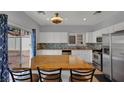 Well-lit kitchen with white cabinets, stainless appliances, island, and access to patio at 9131 Grand Sunburst Ct, Las Vegas, NV 89149
