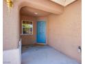 Inviting front porch featuring a blue door, neutral stucco, and small window at 9321 Lady Finger Ct, Las Vegas, NV 89149