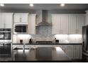 Modern kitchen featuring white cabinets, stainless steel appliances, and gray backsplash at 12495 Point Sierra St, Las Vegas, NV 89138