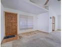 Spacious living room featuring wood door, large window and neutral carpet at 1409 Santa Margarita St # G, Las Vegas, NV 89146