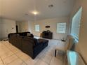 Living room with a sectional sofa, a cushioned bench, tile flooring, and bright windows at 1618 Dakota Group Ave, North Las Vegas, NV 89084