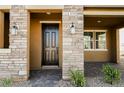 Inviting front entrance featuring stone accents, a covered porch, and stylish exterior lighting at 3240 Avernus Ave, Henderson, NV 89044