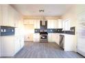 Bright kitchen features white cabinets, stainless steel appliances, and sleek backsplash at 3412 Adventure Ct, Las Vegas, NV 89129