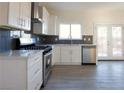 Modern kitchen with stainless steel appliances, white cabinets, and a window over the sink at 3412 Adventure Ct, Las Vegas, NV 89129