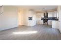Spacious living room with white walls and wood flooring, leading into the modern kitchen at 3412 Adventure Ct, Las Vegas, NV 89129