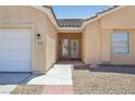 Welcoming facade highlighting the front door, tidy desert landscaping, and a spacious two-car garage on the side at 3538 Canter Dr, North Las Vegas, NV 89032