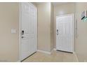 Tiled hallway featuring two white doors with matching hardware and light tan walls at 4020 Smokey Fog Ave # 102, North Las Vegas, NV 89081