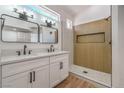 Bathroom with double vanity, modern fixtures, and a walk-in shower with wood paneling at 5321 Marietta Ave, Las Vegas, NV 89108