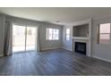 Bright living room featuring new wood floors, a fireplace and sliding glass door to the backyard at 5461 Dungaree St, Las Vegas, NV 89118