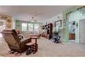 Comfortable living room features plush carpeting, neutral tones, and ample natural light from the large windows at 5896 Shining Moon Ct, Las Vegas, NV 89131