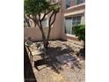 Cozy backyard featuring a seating area with a small tree for shade and a minimalist stone landscape at 59 Belle Maison Ave, Las Vegas, NV 89123