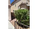 Exterior shot of the building with desert landscaping visible behind a black metal fence at 59 Belle Maison Ave, Las Vegas, NV 89123