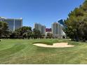 Well manicured golf course with sand traps, lush greenery, and towering buildings in the background at 632 Tam O Shanter, Las Vegas, NV 89109