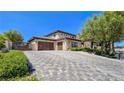 Two-story home showcasing a three-car garage, paver driveway, and manicured landscaping at 8010 Palm Cove Ct, Las Vegas, NV 89129