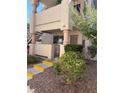 Exterior view of condo with yellow-trimmed stairs, xeriscaping and security door in a residential neighborhood at 925 Falconhead Ln # 102, Las Vegas, NV 89128