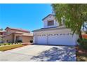 Inviting two-story home with a manicured lawn, a two-car garage, and mature landscaping at 975 Leadville Meadows Dr, Henderson, NV 89052