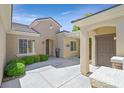 Inviting home entrance featuring a charming courtyard, neutral tones, and manicured landscaping at 2385 Orangeburg Pl, Henderson, NV 89044