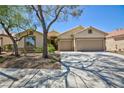 Charming home features a well-manicured front yard, desert landscaping, and a spacious two-car garage at 2475 Sedona Cedar Ave, Henderson, NV 89052