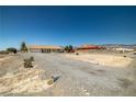 Gravel driveway and front yard leading to a cozy home with a tile roof at 2730 Banyon St, Pahrump, NV 89048
