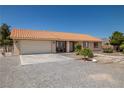 Well-maintained home with a tile roof, attached garage, and landscaped front yard at 2730 Banyon St, Pahrump, NV 89048