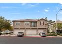 Three-story townhome with a tan exterior, red tile roof and three garages in a well maintained community at 390 Clarence House Ave # 1, North Las Vegas, NV 89032
