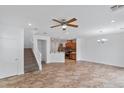 Spacious living room area with staircase, ceiling fan, and easy access to kitchen and backyard at 390 Clarence House Ave # 1, North Las Vegas, NV 89032