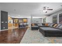 Open-concept living room with hardwood floors, a ceiling fan, and a comfortable gray sectional sofa at 4021 Mountain Trek St, Las Vegas, NV 89129