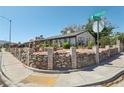 View of a single-story home with brick and stone accents with manicured landscaping at corner at 4027 Maple Hill Rd, Las Vegas, NV 89115