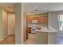 Bright kitchen with stainless steel refrigerator, white appliances, and light wood cabinets at 4672 Regalo Bello St, Las Vegas, NV 89135
