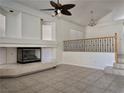 Bright living room features a fireplace, ceiling fan, and a staircase to the second floor at 6608 Buried Treasure Ct, Las Vegas, NV 89139