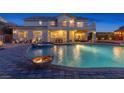 A beautiful backyard with a pool and jacuzzi and outdoor seating at 6958 Lazy Sunset Ct, Las Vegas, NV 89156