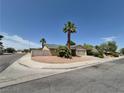 Street view of a well-kept home on a corner lot featuring desert landscaping and mature palm trees at 7104 Carrondale Way, Las Vegas, NV 89128