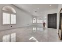 Bright living room featuring large windows and a shiny tile floor at 825 Royal Moon Ave, Las Vegas, NV 89123