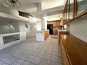 Open kitchen featuring an island, tiled flooring, oak cabinets and seamless access to living area at 9693 Bighorn Island Ave, Las Vegas, NV 89148