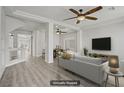Bright living room with modern gray tones, hardwood floors, and stylish ceiling fan at 9784 Kodiak Island Ct, Las Vegas, NV 89141