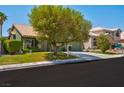 Inviting single-Gathering home with lush front lawn, mature tree, and convenient two-car garage at 9909 Masked Duck Ave, Las Vegas, NV 89117