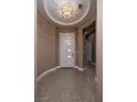Inviting home entryway featuring decorative floor tiles, modern lighting, and a sleek front door at 10349 Bressana Dr, Las Vegas, NV 89135