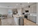 Eat-in kitchen boasts stainless steel appliances, a center island, and stylish gray cabinets with lots of storage at 10630 Adobe Ranch St, Las Vegas, NV 89141