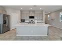 Spacious kitchen features an oversized kitchen island, stainless steel appliances, and tile flooring at 10630 Adobe Ranch St, Las Vegas, NV 89141