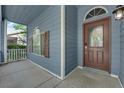 Inviting front porch featuring blue siding, brown door with a 'Welcome' sign and arched window at 1553 Ivygate Ave, Las Vegas, NV 89183