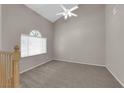 Spacious living room with neutral carpet, vaulted ceiling, and arched window providing natural light at 1553 Ivygate Ave, Las Vegas, NV 89183