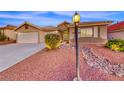 Inviting single-story home featuring desert landscaping and a decorative rock stream in the front yard at 1643 Silver Slipper Ave, Henderson, NV 89002