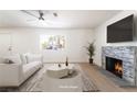 Cozy living area with a stone fireplace, a large window, and neutral tones at 1700 Sweeney Ave, Las Vegas, NV 89104