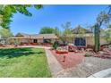 Charming home showcasing xeriscaping, mature trees, and desert landscaping, perfect for enjoying outdoor living at 1705 Westwind Rd, Las Vegas, NV 89146