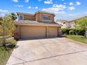 Charming two-story home featuring a three-car garage, well-maintained lawn, and picturesque landscaping at 1870 Desert Forest Way, Henderson, NV 89012