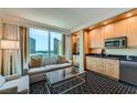 The living room has a couch, TV, and kitchenette with granite counters and city views at 2000 N Fashion Show Dr # 2308, Las Vegas, NV 89109