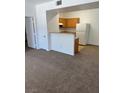 Spacious living room with neutral carpet, with an adjacent kitchen with wood cabinets at 2019 Rancho Lake Dr # 102, Las Vegas, NV 89108