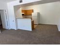 Open living room space featuring neutral carpet, with an adjacent kitchen and white appliances at 2019 Rancho Lake Dr # 102, Las Vegas, NV 89108