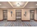 View of the three elevators and patterned carpet of the building at 211 E Flamingo Rd # 402, Las Vegas, NV 89169